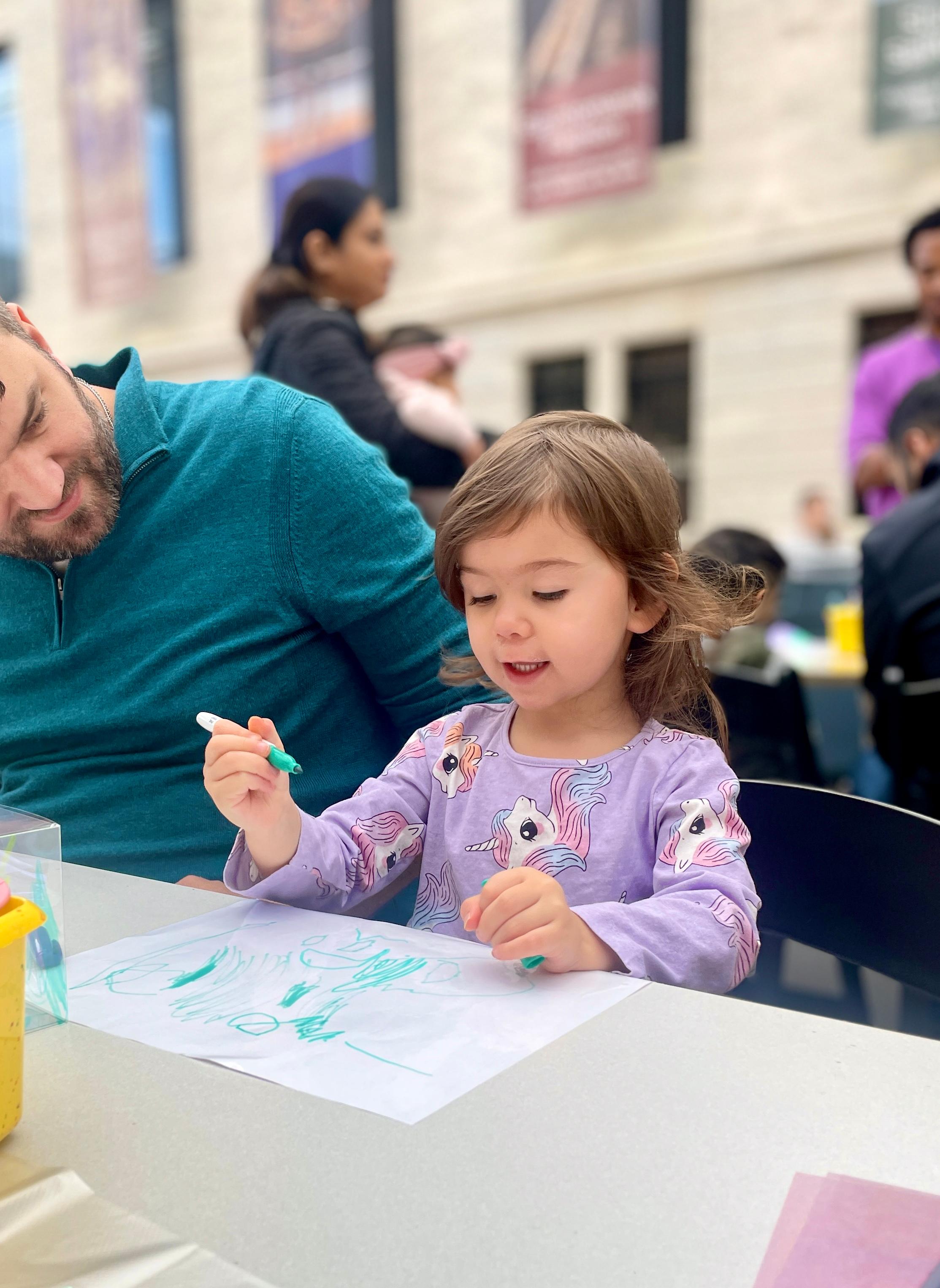 Child drawing with marker at a table