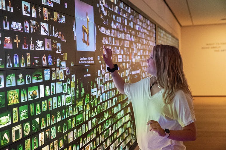 A visitor interacting with the colorful ArtLens Wall