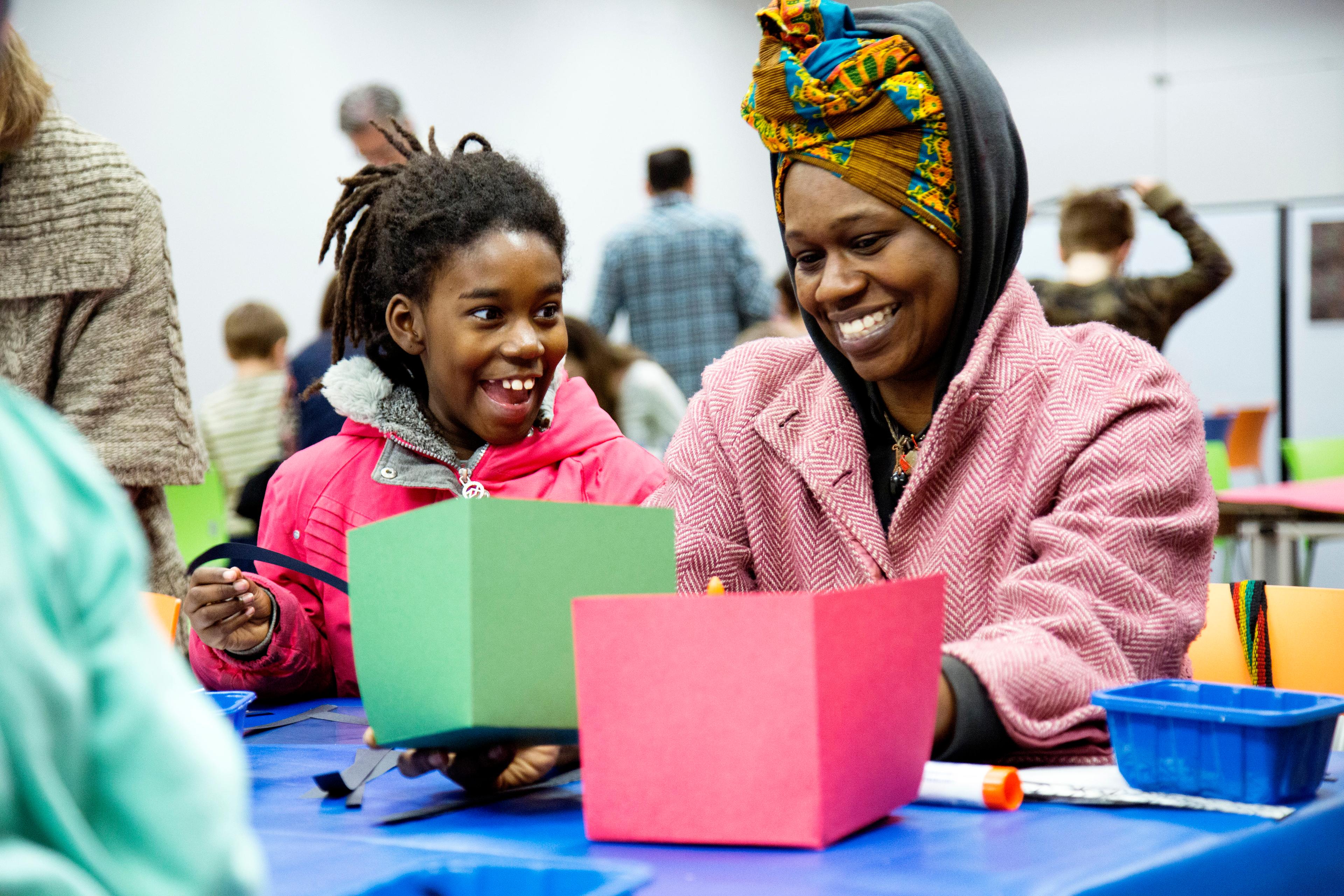 Adult and child making artwork together at a table