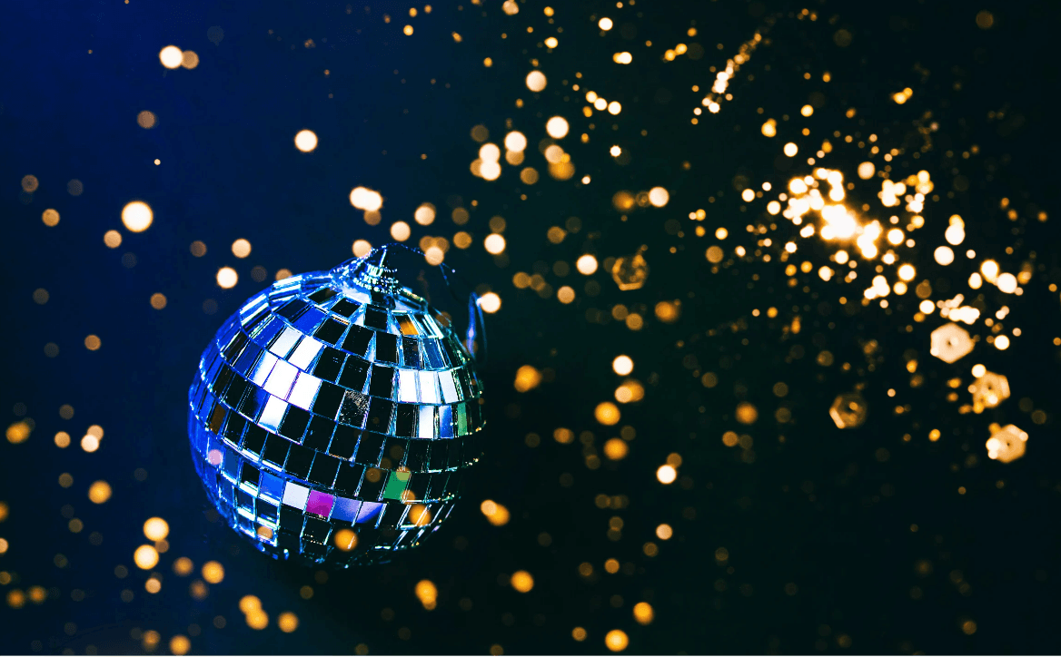 Image of disco ball against a black, sparkly backdrop